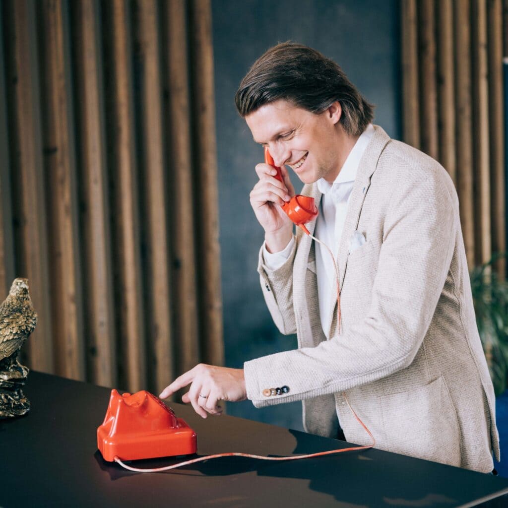 Patrick Schöpfer mit einem roten Telefon